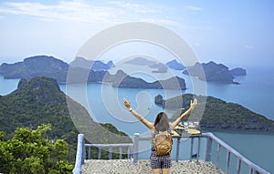 Women raise their arms and shoulder backpack on Pha Jun Jaras Viewpoint at Angthong Islands , Suratthani in Thailand