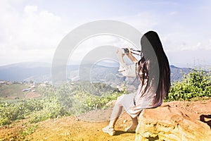 Women rare view sit on the rock shooting photo at the hill with photo