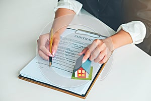 Women Real Estate Agent showing where to sign on document for bu