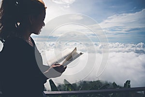 Women relax Read morning book good weather sky Mist. On the mountains, the morning atmosphere