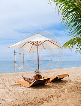 Women relaxing on a beach chair sunny day with hammock on beach in Pattaya Thailand Ban Amphur beach