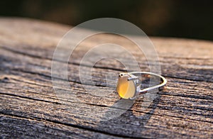 Women ring with chalcedony agate gemstone on wood