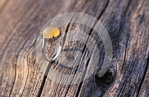 Women ring with chalcedony agate gemstone on wood