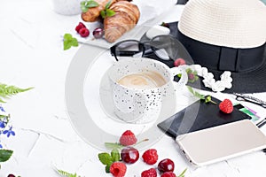 Women`s accessories, lady on vacation. Sunglasses and hat, croissant and coffee for breakfast. White background. Copy space. Flat