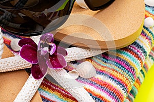 Women`s Beach Flip Flops, Colorful Striped Beach Towels and black Sunglasses decorated with Starfish on yellow background