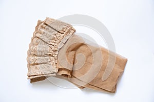 Women`s beige nylon stockings on a white background close up