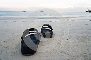 Women`s casual shoes on the beach Evening time With fishing boats in the background