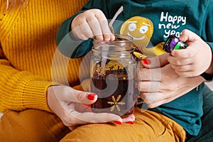 Women`s and child`s hands holding a mug can of tea. Party time. Tea jar with drink