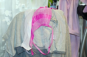 Women`s clothes hanging in a chair. Women`s pink bra. Fetish
