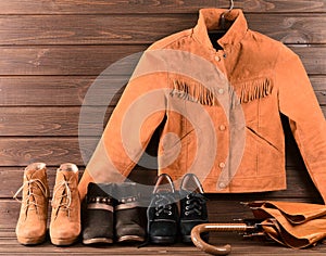 Women's clothing and accessories. Brown suede jacket, three different pairs of shoes and umbrella