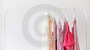 Women`s clothing blouses in pink, beige and cream shades on a white hanger