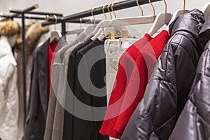 Women's clothing on hangers in a boutique. Dresses, jackets, skirts and trousers