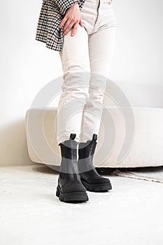 Women& x27;s comfortable winter boots. Casual style for every day. Studio shot. Fashion girl in white pants and jacket