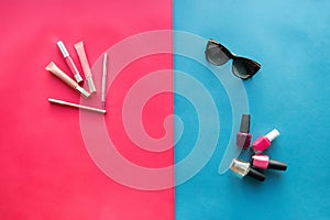 Women`s cosmetics, sunglasses and nail Polish on a blue and red