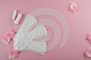 Women`s cycle hyhienic pads and tampons on pink background. Copy space