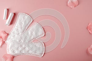 Women`s cycle hyhienic pads and tampons on pink background. Copy space