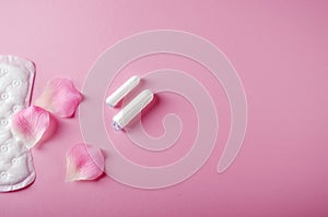 Women`s cycle hyhienic pads and tampons on pink background. Copy space