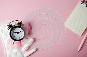 Women`s cycle hyhienic pads and tampons on pink background. Copy space