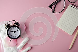 Women`s cycle hyhienic pads and tampons on pink background. Copy space