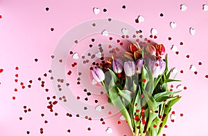 Tulip flowers and small hearts on soft pink background