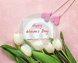 Women`s Day greeting message with white tulips and hearts on pin