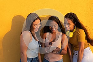 Women`s Diversity, Girl Power, Femininity Concept. Group Of Three Happy Young Women Holding Cellular