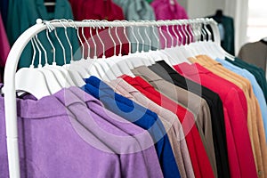 Women's dresses on hangers in a retail shop. Row of different female clothes hanging on rack in fashion show room