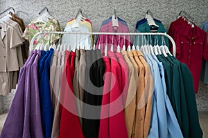 Women's dresses on hangers in a retail shop. Row of different female clothes hanging on rack in fashion show room