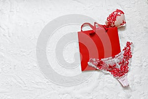Women`s erotic lingerie on white surface. Red lacy underwear on white background. Concept of love. Flat lay. Copy space