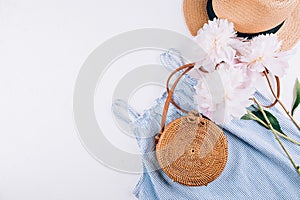 Women`s fashion summer clothes, accessories. Stylish female straw hat, blue dress, rattan bag, peony