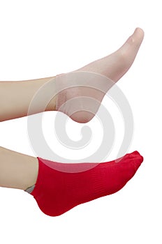 Women`s feet in different socks. Red and pink sock on the legs of a young woman