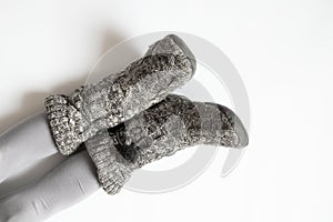 Women's feet in gray slippers on a white background, home shoes, legs