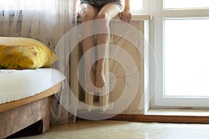 Women`s feet on an old cast-iron battery in an apartment in winter, a cold apartment, a heating season, a battery in an apartment