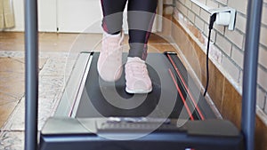 Women's feet walking on a treadmill machine to exercise and stay in shape.