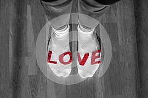 Women& x27;s feet with white and red socks and written the word LOVE