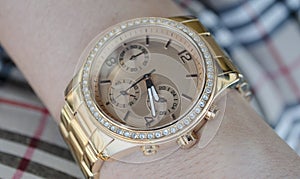 Women's gold watch on the hand