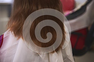 Women`s haircut in a Barber shop. Master universal cuts, evens the girl`s hair with a comb and scissors