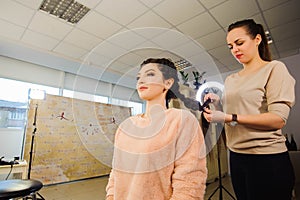 Women`s haircut. hairdresser, beauty salon. Beautiful woman getting haircut by hairdresser in the beauty salon