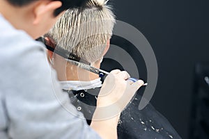 Women`s haircut. Hairdresser, beauty salon. Professional hairdresser making stylish haircut. Hairdresser cutting woman bangs hair