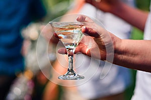 Women`s hand with a glass of Martini close-up