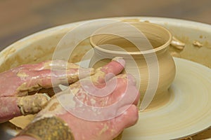 Women`s hand molding clay on a pottery wheel. Revival of folk crafts. Shaping clay on pottery wheel