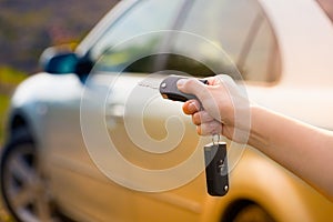 Women's hand presses on the remote control car alarm