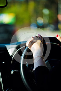 Women& x27;s hand on the steering wheel of a car