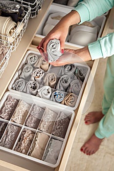 Women`s hands close up. Storage of socks. Boxes for underwear.