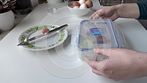 Women's hands are closing a lunch-box with a healthy meal