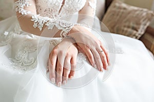 Women`s hands folded on their knees in anticipation of the wedding and the groom