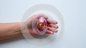 Women's hands hold a chocolate egg love surprise opens and closes it with the palm of her hand