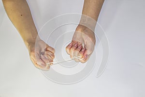 Women`s hands hold the rope in the light background. Female hands pull the rope between each other. Hands pull the rope