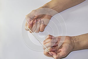 Women`s hands hold the rope in the light background. Female hands pull the rope between each other. Hands pull the rope