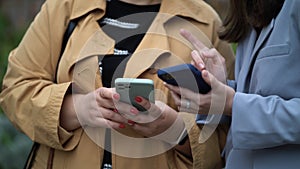 Women& x27;s hands hold smartphones. Women communicate and use phones